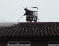 pressure washing concrete roof tiles on a house