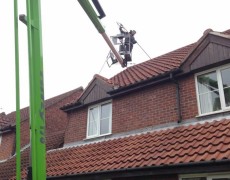 power washing roof on a house from a cherry picker